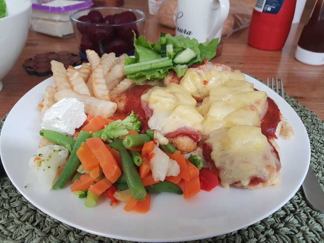 chicken parmigiana with cheese, pineapples, chips, carrots, beans, cauliflour, green salad and barbeque sauce and tomato paste