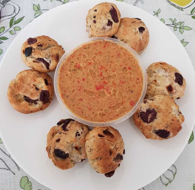 capsicum dip and olive bread on white plate